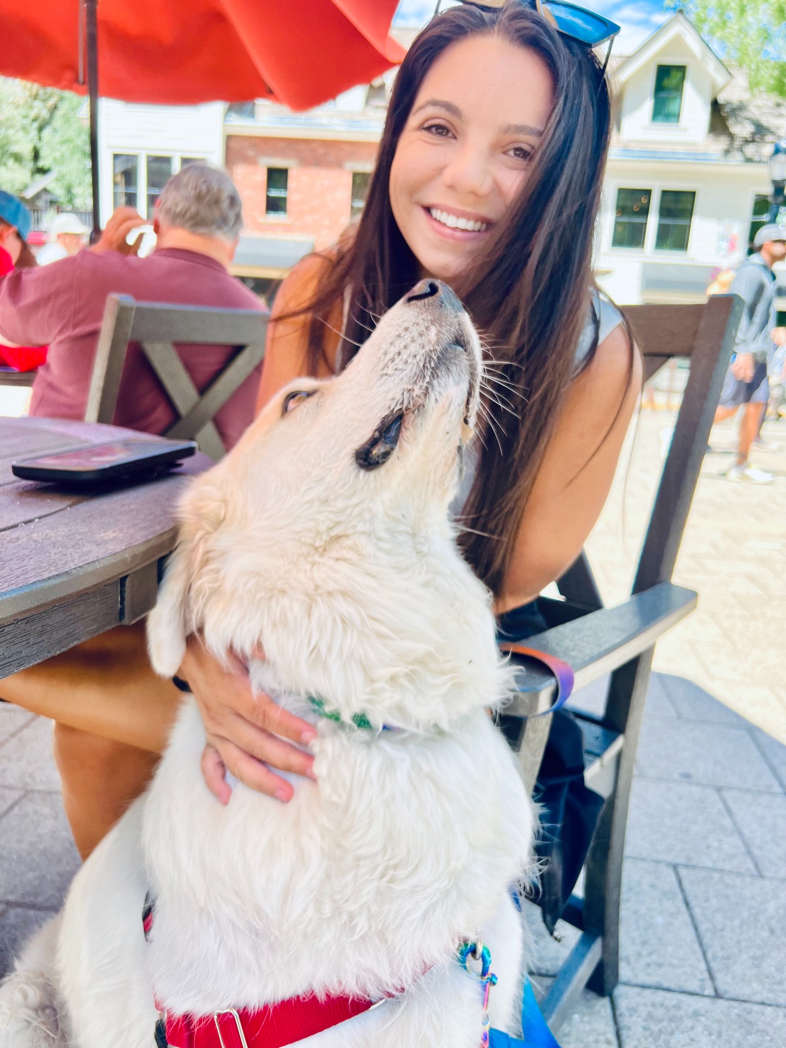 Briana smiling while holding a happy white dog